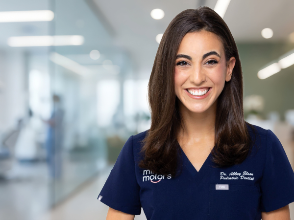 Smiling woman in dental scrubs in dental office setting